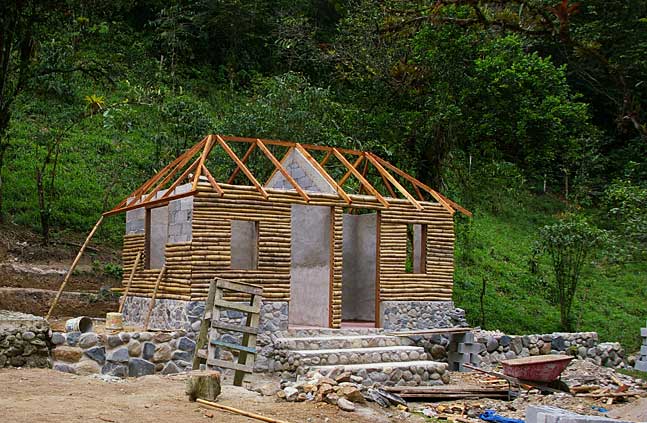 Photo of a little mountain cabin with natural stone foundations and wood and cement wall elements