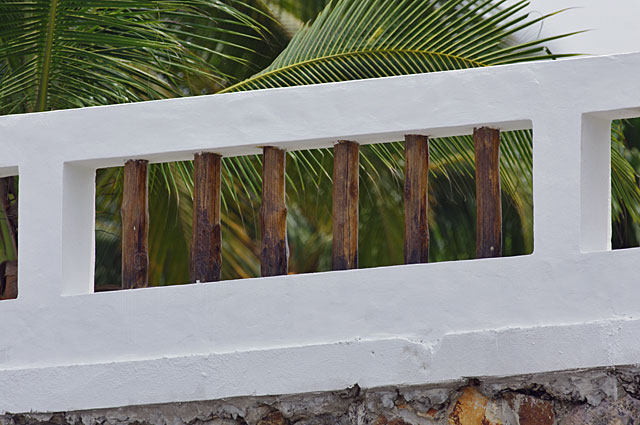 Photo Example of a good looking beach house fence made of cement frames painted in white and natural wood