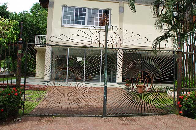 Photo example of beautiful metal artwork on a gate in front of a remodeled house