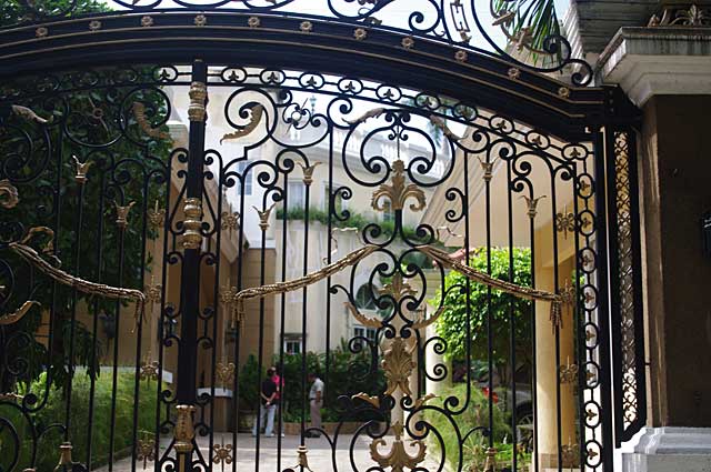 Photo example of luxurious metal artwork on a gate in front of a exclusive town house