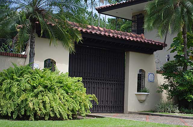 Photo example of black security gate in front of colonial styled house