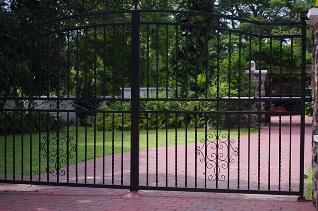 Photo example of simple but elegant black metal gate in front of colonial house