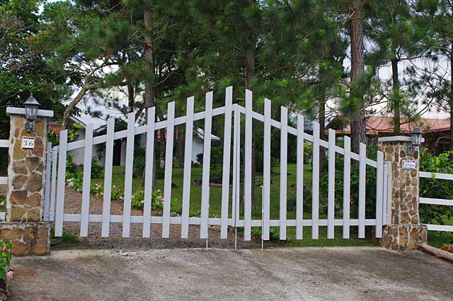 Photo example of simple but elegant white gate in front of country house