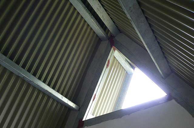 Example photo of the inside of a house under construction with a simple zinc roofing