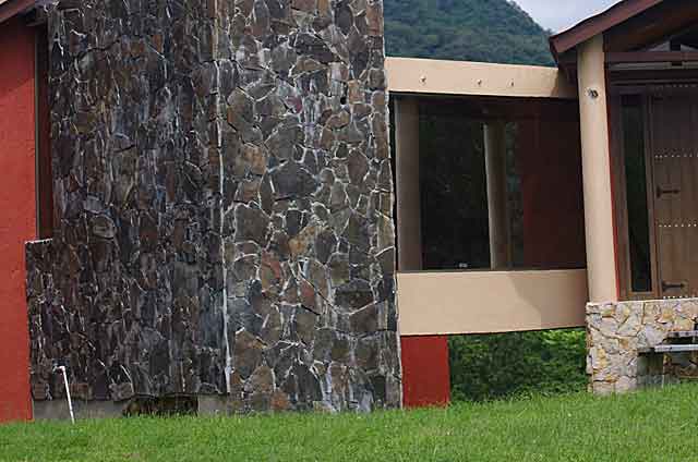 Photo example of a wall on a country home covered with dark grey almost black stone plates