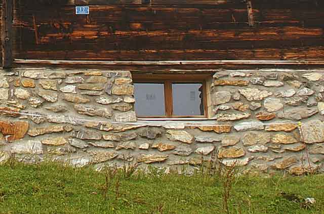 Photo example of a wall on a Swiss alpine mountain house built with local natural beige stone plates