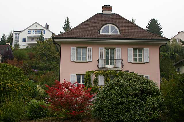 Photo example of a classic 2 story villa in Switzerland, painted in a light pastel salmon color