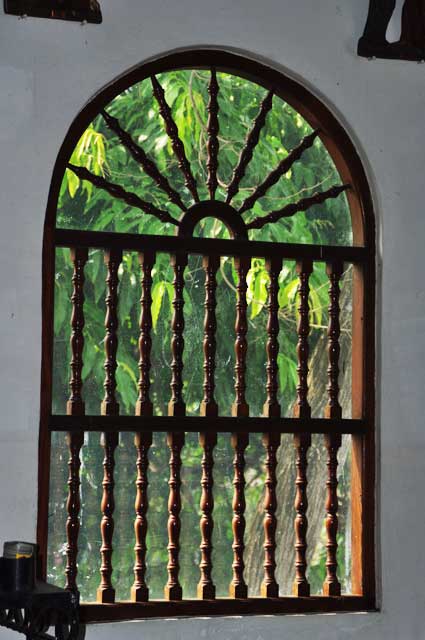Photo example of an old colonial window without glass but with a decorative wooden frame