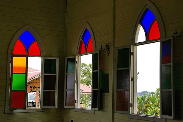 Photo example of an old church window with colored glass panels, this is a Caribbean style church
